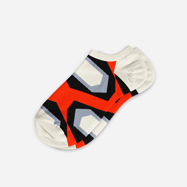 A digital mockup of geometric red socks with yellow toe and heels, on a light grey background.