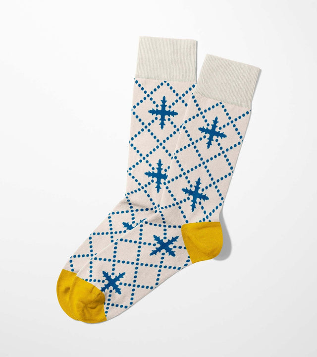 A digital mockup of blue floral socks with yellow toe and heels, on a light grey background.