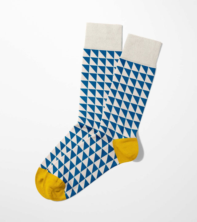 A digital mockup of blue geometric socks with yellow toe and heels, on a light grey background.