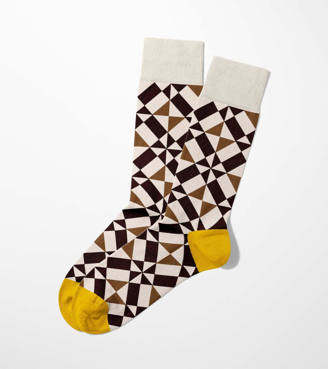 A digital mockup of geometric brown socks with yellow toe and heels, on a light grey background.