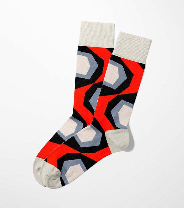 A digital mockup of geometric red socks with yellow toe and heels, on a light grey background.