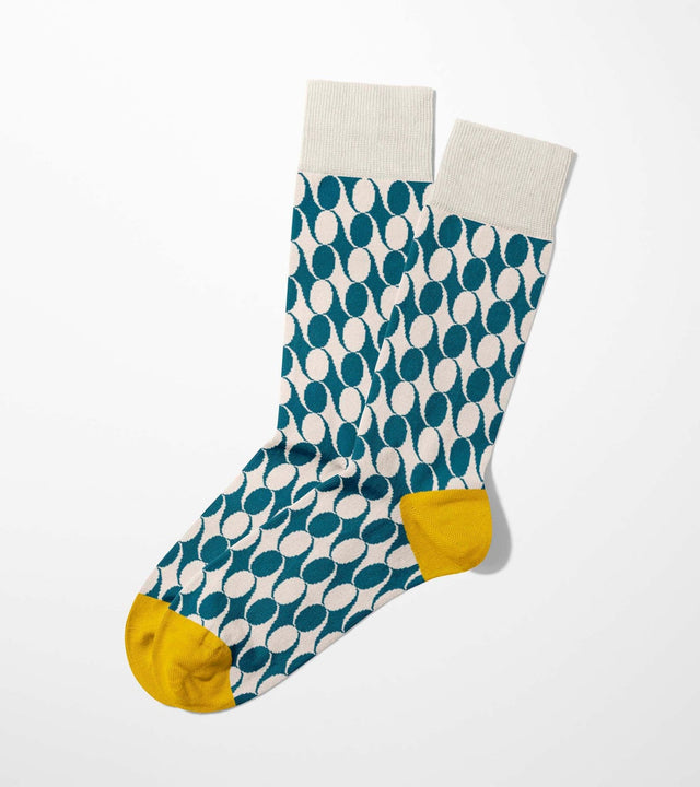 A digital mockup of blue geometric pattern socks with yellow toe and heels, on a light grey background.