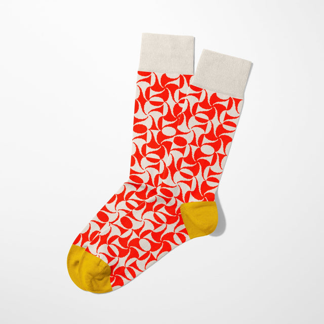 A digital mockup of red geometric pattern socks with yellow toe and heels, on a light grey background.