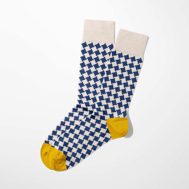A digital mockup of blue geometric socks with yellow toe and heels, on a light grey background.