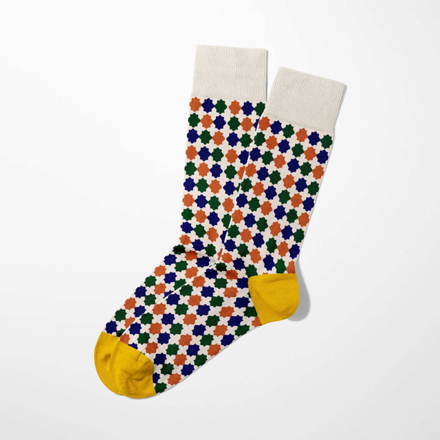 A digital mockup featuring colored geometric socks with yellow toe and heels, set against a light grey background.